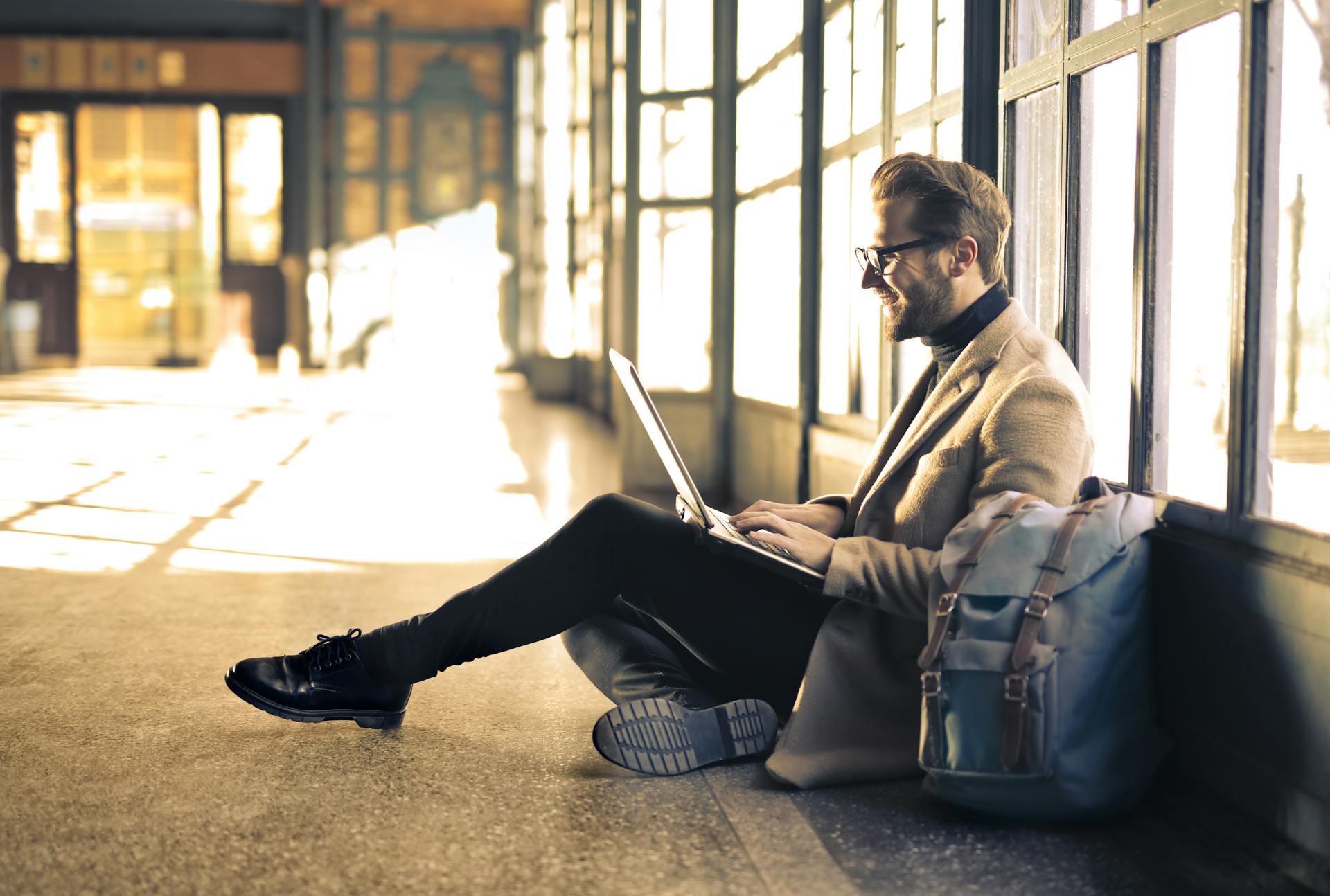 Professional using a laptop while sitting in a modern workspace, symbolizing communication and online contact