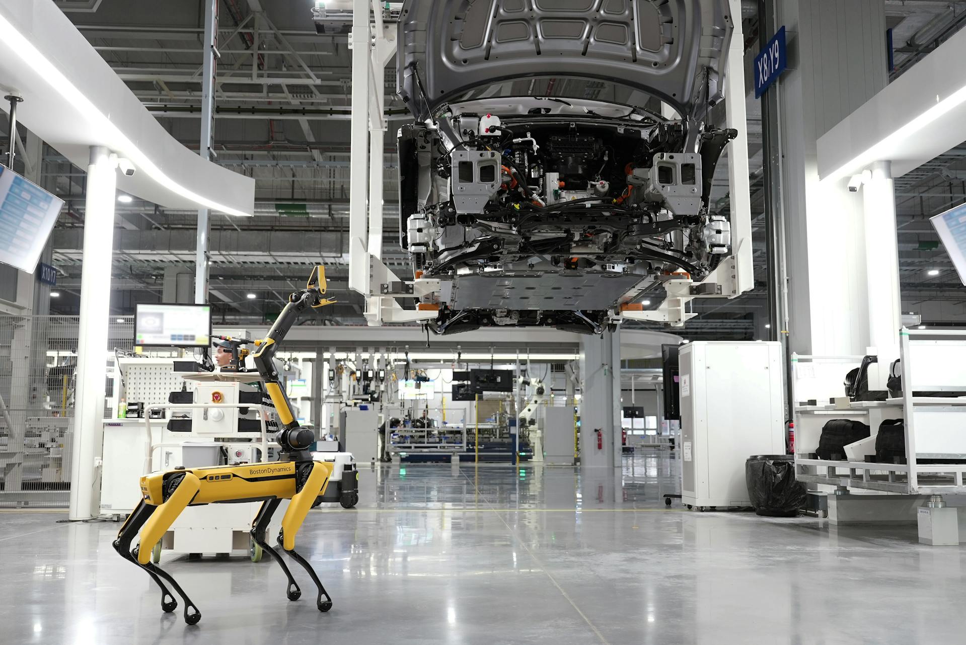 Autonomous robot inspecting a vehicle chassis in a smart automotive manufacturing facility with advanced automation technology